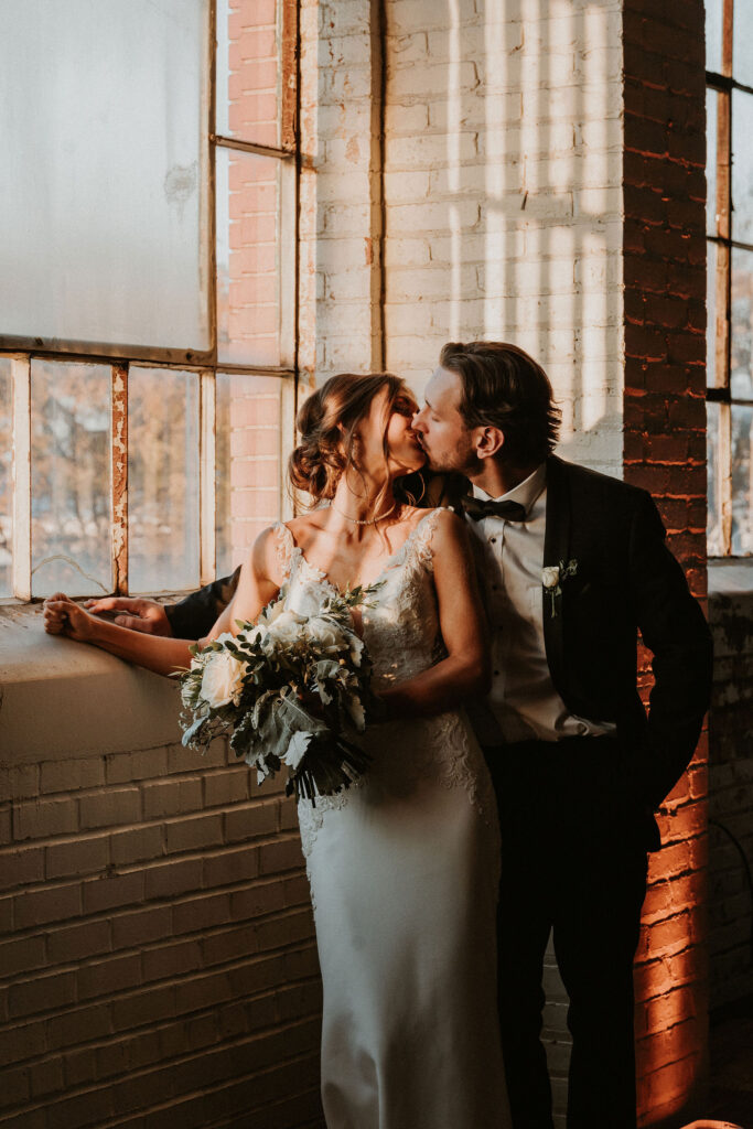 Cleveland couple cozying up with golden light filtering through the windows at BLDG17 wedding venue