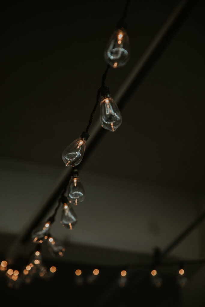 Hundreds of string lights drape along the ceiling for moody and modern wedding vibes