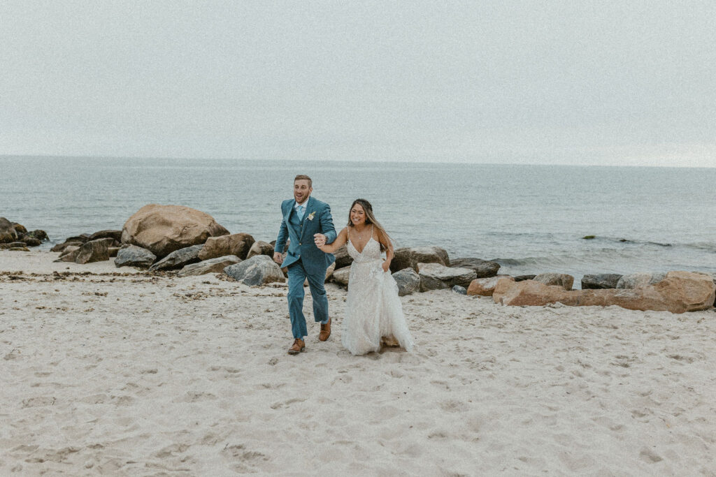 Mai and Matt frolicking on the beach after getting married at Eolia Mansion