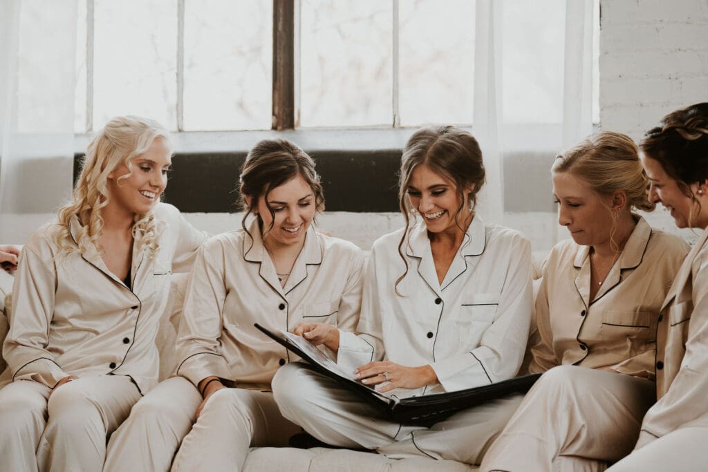 The bridal party looking at the photo album together in the getting ready suite