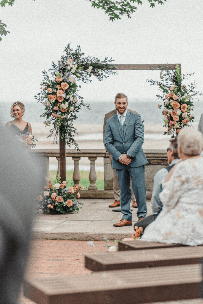 Groom waiting for the ceremony to start with the Connecticut coastline in the background